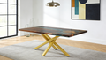 Modern dining table with wooden surface and metal legs in a room with a painting on the wall.